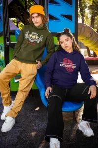 comfort colors hoodie mockup of a man and a woman posing in a playground
